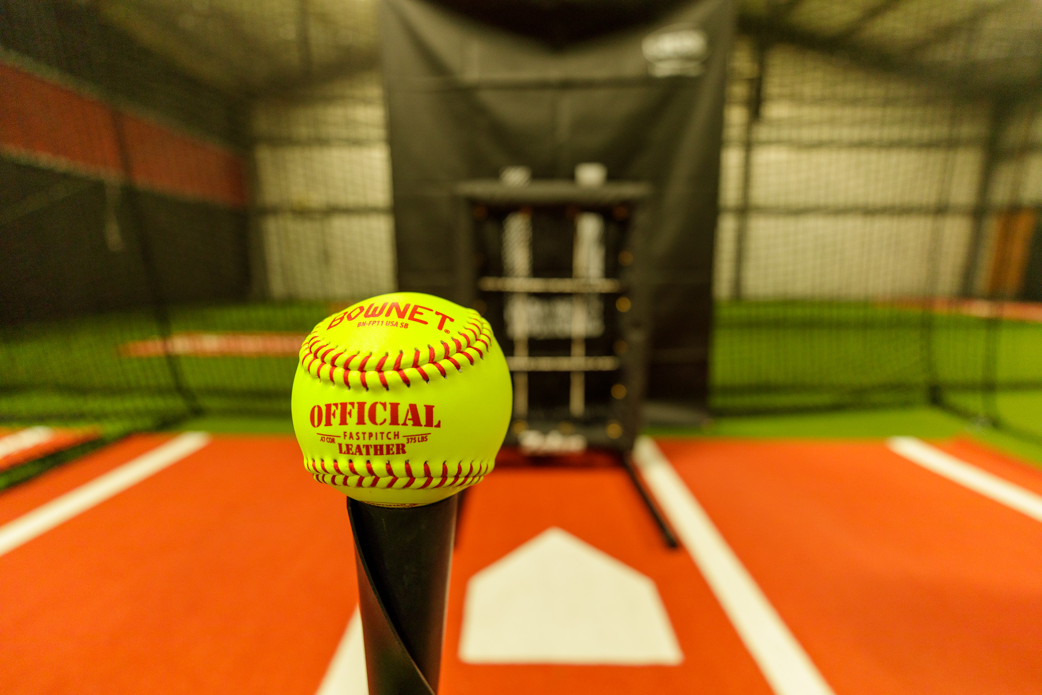 Softball on batting tee in tunnel